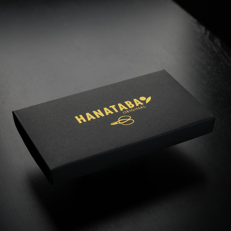 Une boîte noire élégante avec "HANATABA ORIGINAL" en lettres dorées et le logo de la marque sur le dessus.