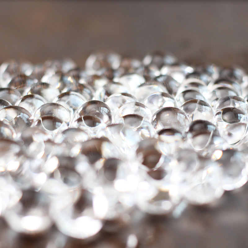 Gros plan sur les bulles d'eau Hanataba, utilisées pour stabiliser et hydrater les compositions florales.