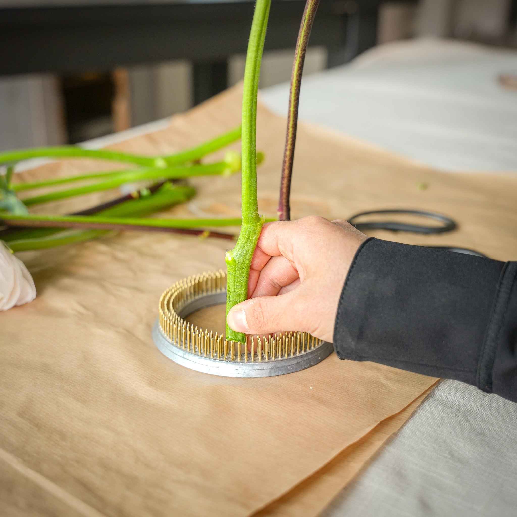 Floral arrangement example where a florist's hand is using the Kenzan Ring 120mm to demonstrate ease of use and effectiveness